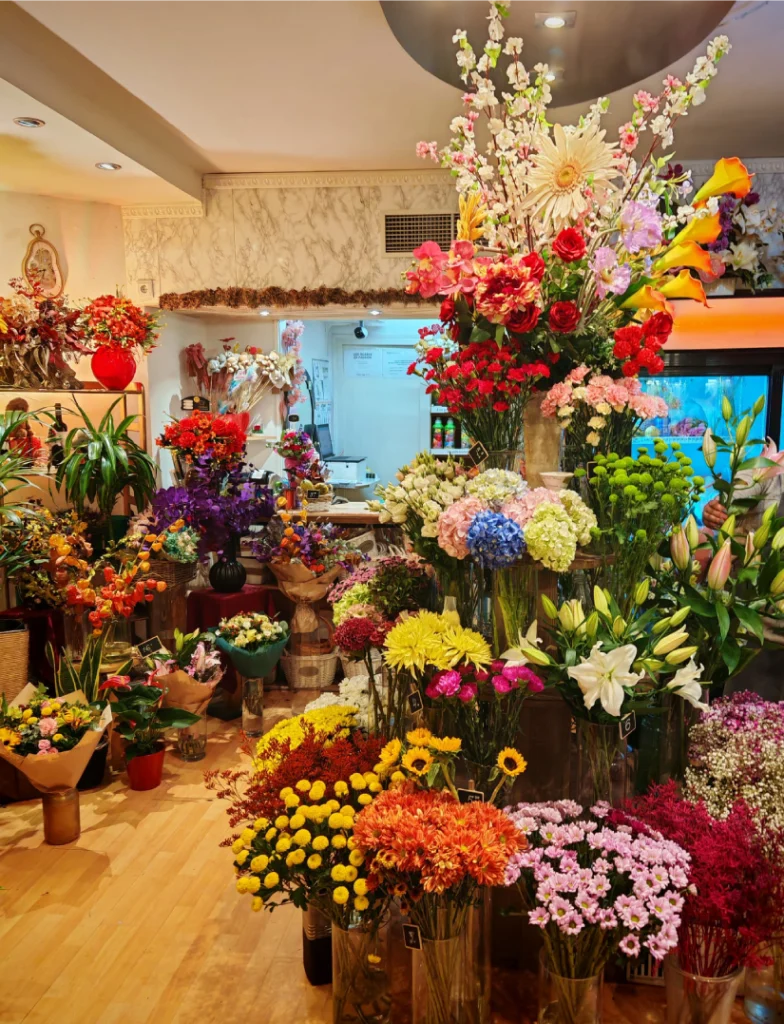 Interior de una floristería con estantería escalonada circular y plantas por todas partes