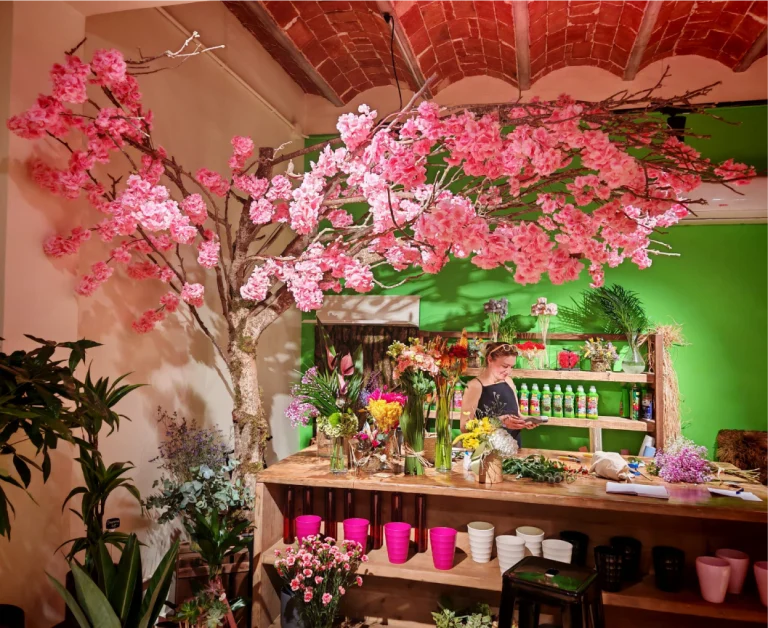 Obra de arte floral, creado con ramas en forma de árbol, con la copa llena de flores rosas