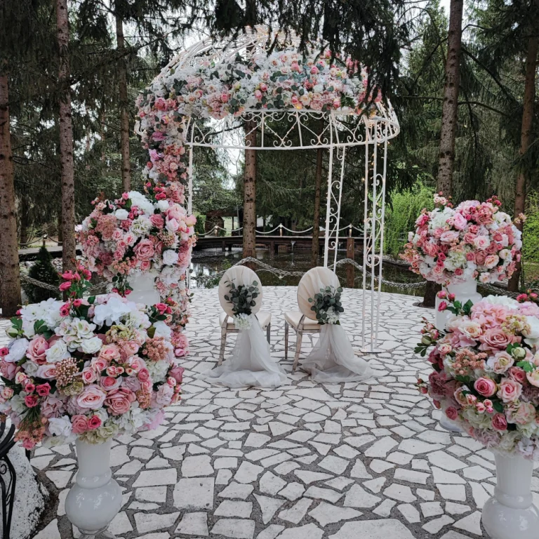 Altar nupcial con arco y decorado con muchas flores blancas y rosas